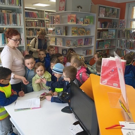 Dyrektor Janina Herzyk tłumaczy dzieciom zasady wypożyczania książek. 