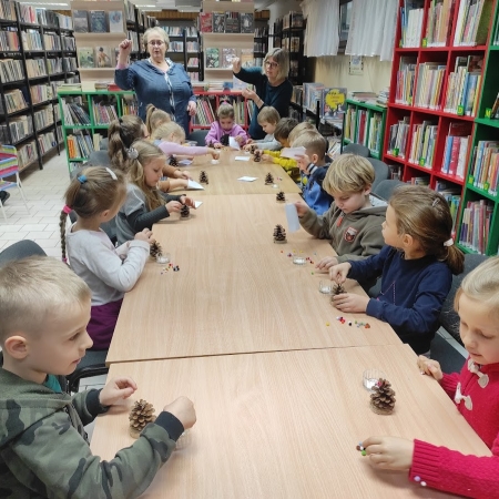 Fotografia kolorowa. Przedszkolaki wykonują prace plastyczne.