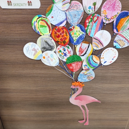 Fotografia kolorowa. Prace plastyczne grupy przedszkolnej "Skrzaty", wywieszone na ladzie bibliotecznej w Górkach Małych. 