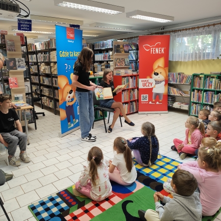  Fotografia kolorowa.  Zdjęcie grupowe przedszkolaków w pomieszczeniu biblioteki.