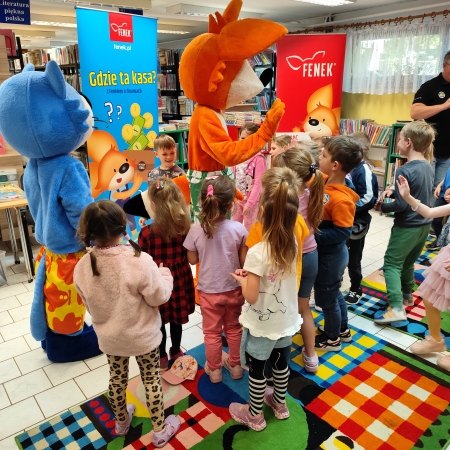  Fotografia kolorowa. Zdjęcie grupowe przedszkolaków w pomieszczeniu biblioteki.