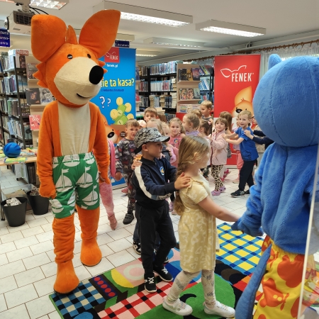  Fotografia kolorowa. Zdjęcie grupowe przedszkolaków w pomieszczeniu biblioteki.