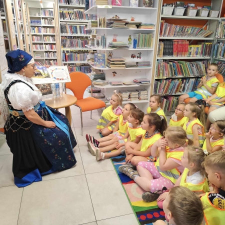 Fotografia kolorowa. Przedszkolaki słuchają bajki.