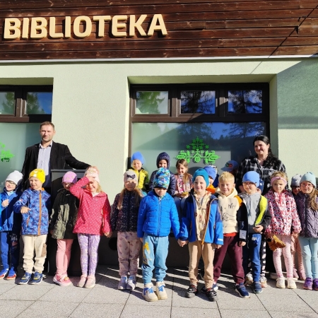 Fotografia kolorowa. Zdjęcie grupowe przed biblioteką. 