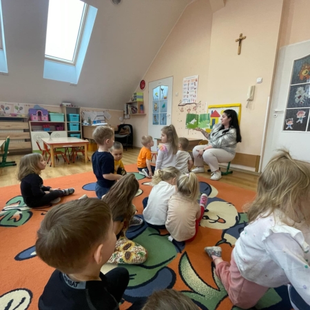 Fotografia kolorowa. Przedszkolaki słuchają bajki. 