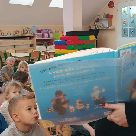 Fotografia kolorowa. Przedszkolaki słuchają opowieści.