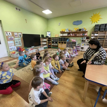 Fotografia kolorowa. Przedszkolaki słuchają opowieści.