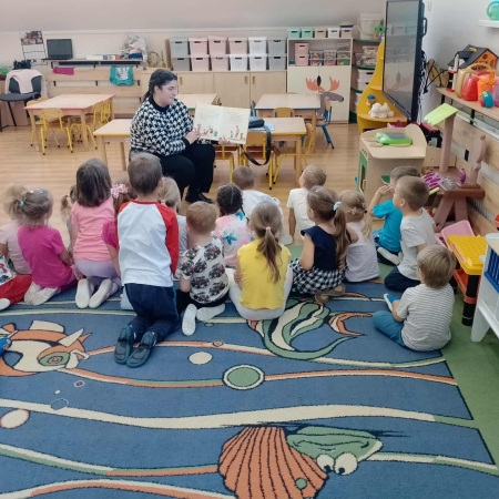 Fotografia kolorowa. Przedszkolaki słuchają opowieści.