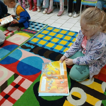 Fotografia kolorowa. Dzieci przeglądają książki w bibliotece.