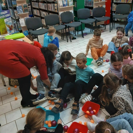 Fotografia kolorowa. Zdjęcie grupowe we wnętrzu biblioteki w Górkach Małych.