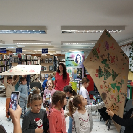 Fotografia kolorowa. Zdjęcie grupowe we wnętrzu biblioteki w Górkach Małych.