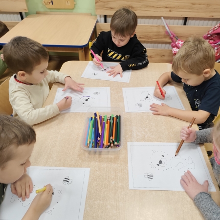 Fotografia kolorowa. Dzieci i ich misiowe prace plastyczne.