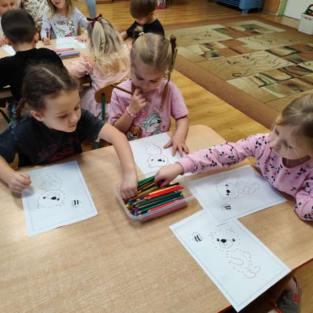 Fotografia kolorowa. Dzieci i ich misiowe prace plastyczne.