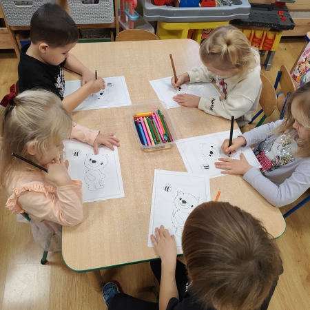 Fotografia kolorowa. Dzieci i ich misiowe prace plastyczne.