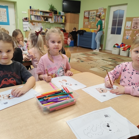 Fotografia kolorowa. Dzieci i ich misiowe prace plastyczne.