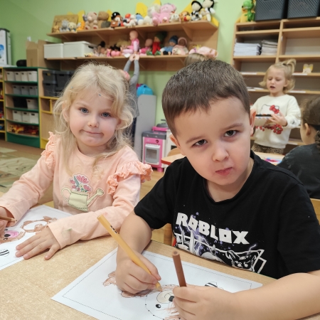 Fotografia kolorowa. Dzieci i ich misiowe prace plastyczne.