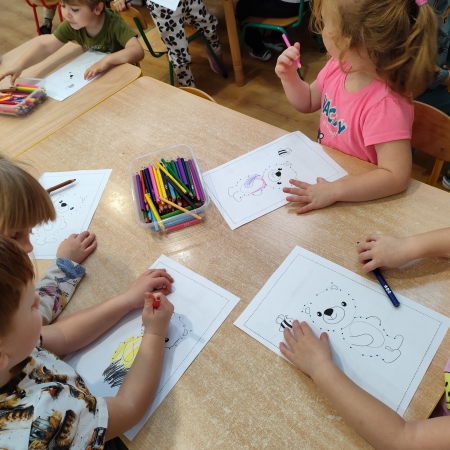 Fotografia kolorowa. Dzieci i ich misiowe prace plastyczne.