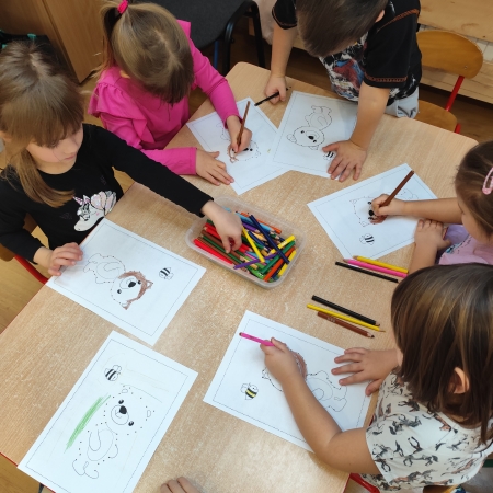 Fotografia kolorowa. Dzieci i ich misiowe prace plastyczne.