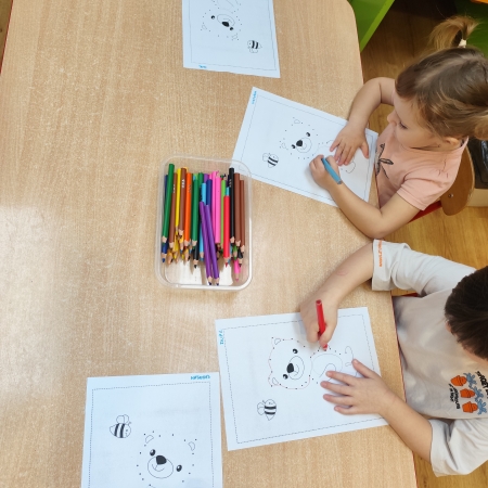 Fotografia kolorowa. Dzieci i ich misiowe prace plastyczne.