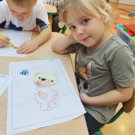 Fotografia kolorowa. Dzieci i ich misiowe prace plastyczne.