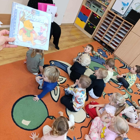 Fotografia kolorowa. Bibliotekarka robi dzieciom misiowy quiz. 