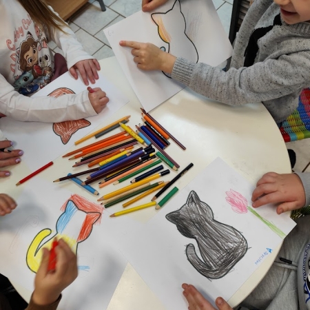 Fotografia kolorowa. Dzieci wykonują prace plastyczne we wnętrzu filii w Górkach Małych.