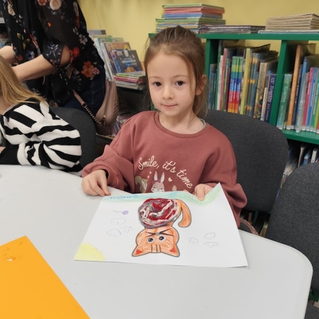 Fotografia kolorowa. Uczennica i jej praca plastyczna.