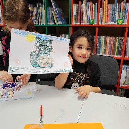 Fotografia kolorowa. Uczennica i jej praca plastyczna.