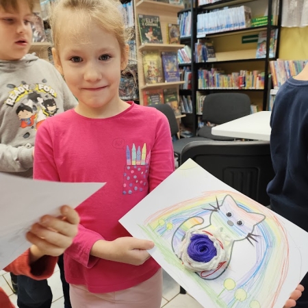 Fotografia kolorowa. Uczennica i jej praca plastyczna.