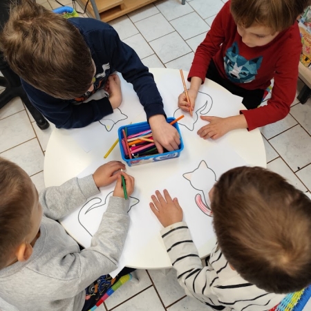 Fotografia kolorowa. Dzieci wykonują prace plastyczne we wnętrzu filii w Górkach Małych.