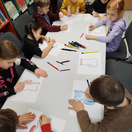 Fotografia kolorowa. Dzieci wykonują prace plastyczne we wnętrzu filii w Górkach Małych.