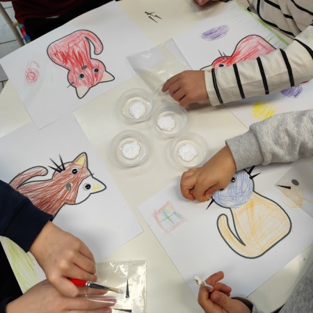 Fotografia kolorowa. Dzieci wykonują prace plastyczne we wnętrzu filii w Górkach Małych.