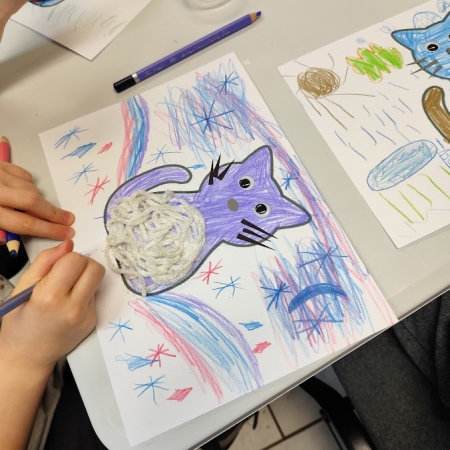 Fotografia kolorowa. Dzieci wykonują prace plastyczne we wnętrzu filii w Górkach Małych.