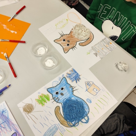 Fotografia kolorowa. Dzieci wykonują prace plastyczne we wnętrzu filii w Górkach Małych.