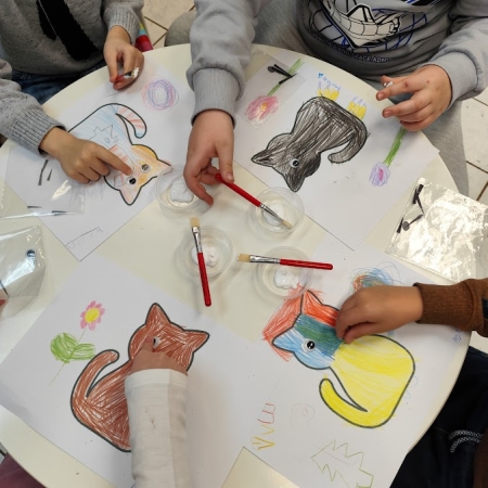 Fotografia kolorowa. Dzieci wykonują prace plastyczne we wnętrzu filii w Górkach Małych.