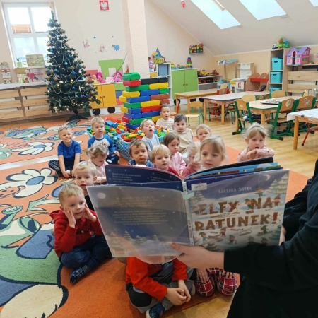 Fotografia kolorowa. Dzieci słuchają bajki "Elfy na ratunek". 