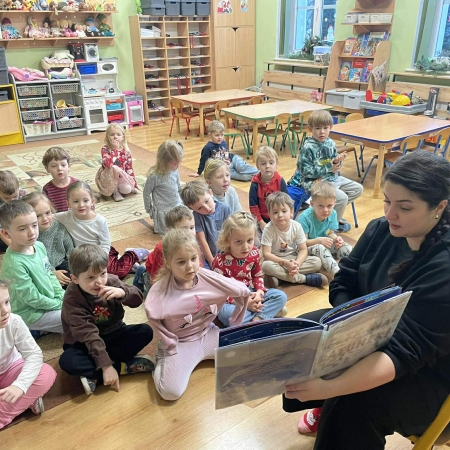 Fotografia kolorowa. Dzieci słuchają bajki "Elfy na ratunek". 