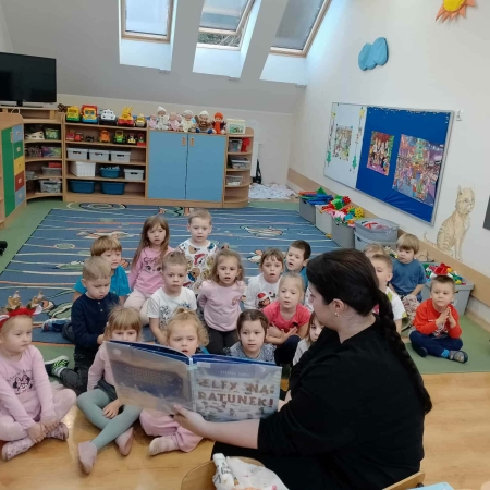 Fotografia kolorowa. Dzieci słuchają bajki "Elfy na ratunek". 