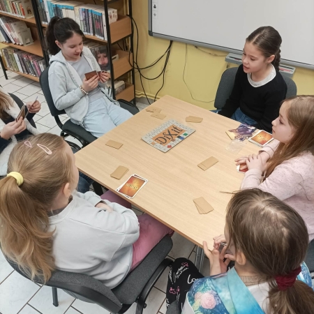 Fotografia kolorowa. Dzieci grają w planszówki w bibliotece w Górkach Małych.