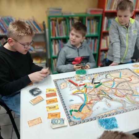 Fotografia kolorowa. Dzieci grają w planszówki w bibliotece w Górkach Małych.