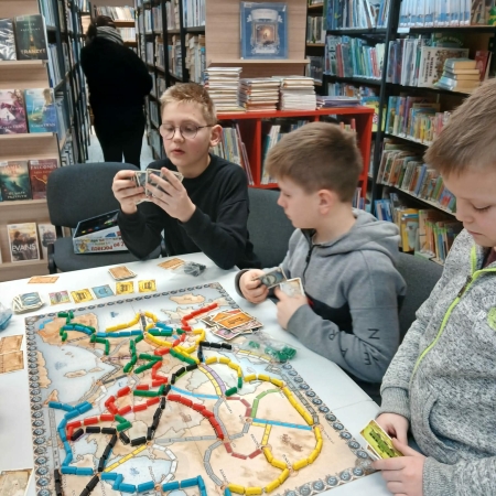 Fotografia kolorowa. Dzieci grają w planszówki w bibliotece w Górkach Małych.