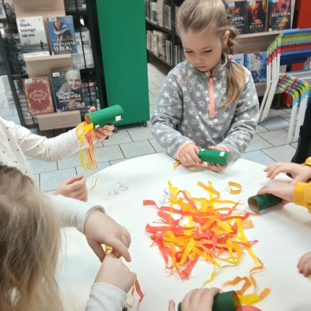 Fotografia kolorowa. Przedszkolaki wykonują prace plastyczne w bibliotece w Górkach Małych. 