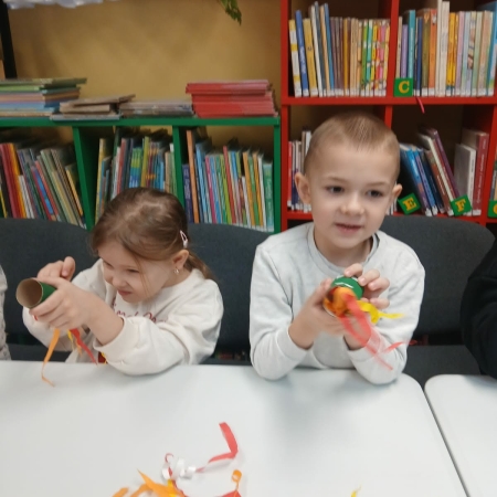 Fotografia kolorowa. Przedszkolaki wykonują prace plastyczne w bibliotece w Górkach Małych. 