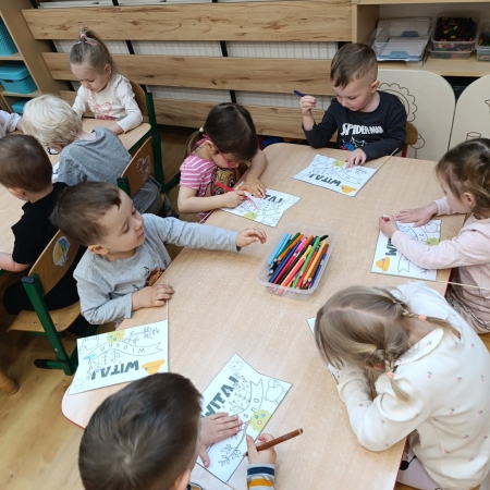 Fotografia kolorowa. Przedszkolaki wykonują prace plastyczne.