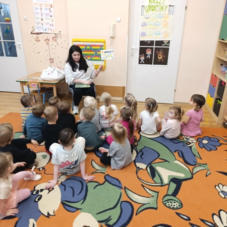 Fotografia kolorowa. Przedszkolaki słuchają bajki. 